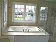 Large Jacuzzi tub surrounded with double hung windows makes this master bath light & bright