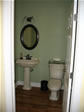 First floor half bath with elegant pedestal sink, matching toilet, specialty hardware and mirror