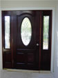 Open and airy foyer hosts this oval front entry door with half sidelites and stained glass design