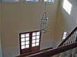 View of a double front door from the second floor hallway of this “open to above” foyer