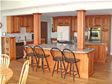 Stylish oak kitchen with oversized center island and decorative columns add support and style