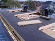 A special modular home installation set crew installs the roof materials and dormers 